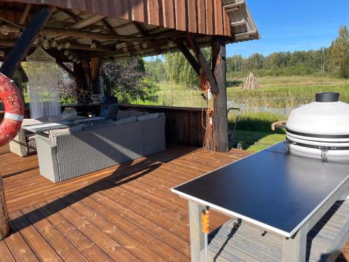 a grill on a wooden deck with a gazebo at Wiire old fishermans farmhouse and smoke sauna in Saulepa
