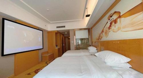 a room with two beds and a projection screen at Vienna Hotel Guangxi Fangcheng in Fangcheng