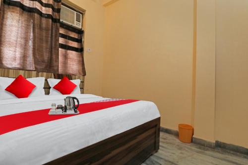 a bedroom with a bed with red pillows at Hotel O Green Lane Valley in Kaliānpur