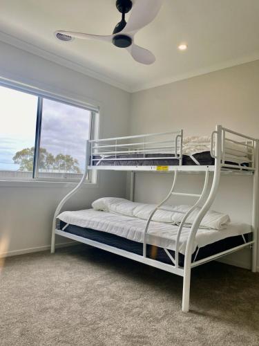 a bunk bed in a room with a ceiling fan at Spacious Holiday Home - 500m from the Beach! in Saint Leonards