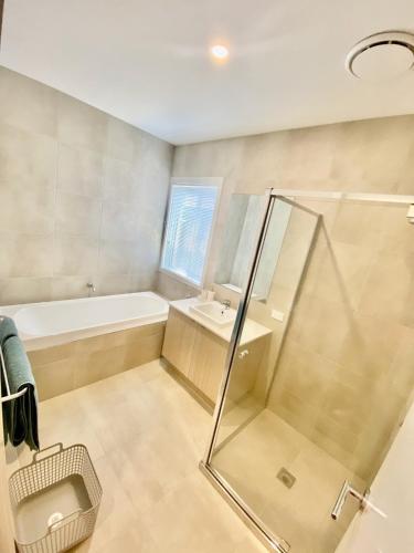 a bathroom with a shower and a tub and a sink at Spacious Holiday Home - 500m from the Beach! in Saint Leonards