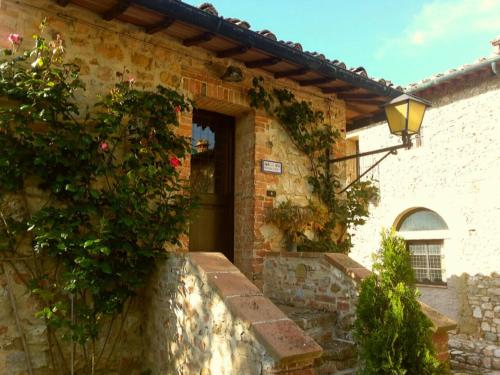 a brick building with a door with flowers on it at Borgo Il Poggiaccio Residenza d'Epoca in Sovicille