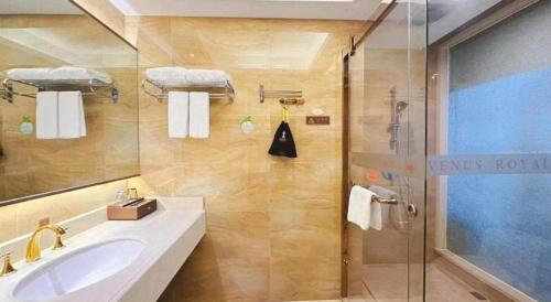 a bathroom with a sink and a shower at Venus Royal Hotel Nanning East High-Speed Railway Station in Nanning