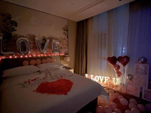a bedroom with a bed with a love sign on it at Vienna Hotel Hangzhou East Railway Station West Square in Hangzhou