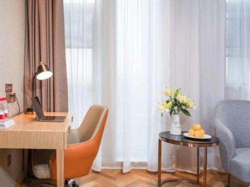 a room with a desk with a laptop and a chair at Vienna Hotel Hangzhou East Railway Station West Square in Hangzhou