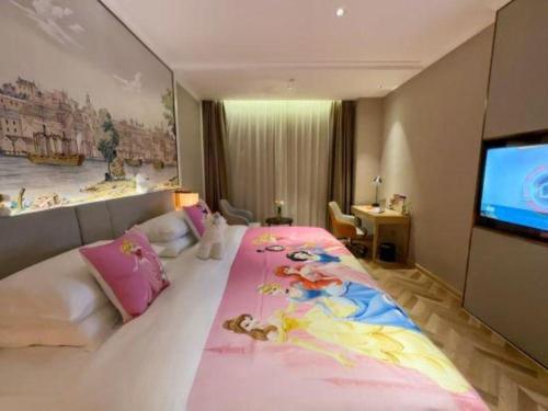 a bedroom with a large bed with a large screen at Vienna Hotel Hangzhou East Railway Station West Square in Hangzhou