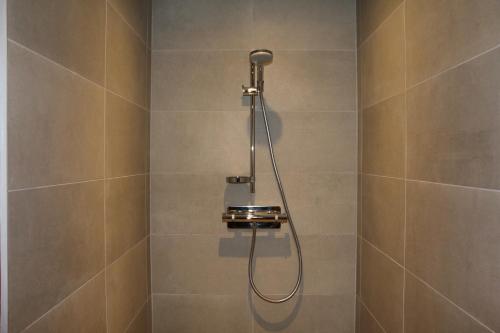a shower with a shower head in a bathroom at Hotel Jean Moët in Épernay