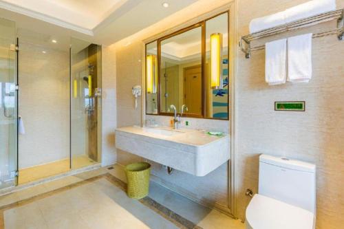 a bathroom with a sink and a shower and a toilet at Venus International Hotel Guangdong Meizhou Fengshun Huamao Hot-Spring in Tangkeng