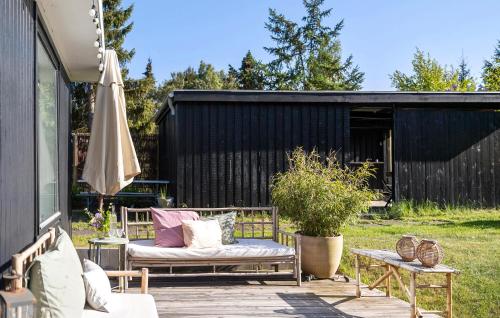 - une terrasse avec 2 bancs et un parasol dans l'établissement Gorgeous Home In Højby With Wifi, à Højby
