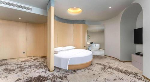 a bedroom with a large white bed in a room at Borrman Hotel Jining High-tech Huangtun in Jining