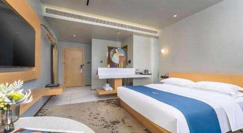a bedroom with a large bed and a sink at Borrman Hotel Jining High-tech Huangtun in Jining