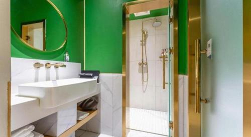 a green bathroom with a sink and a shower at Borrman Hotel Jining High-tech Huangtun in Jining