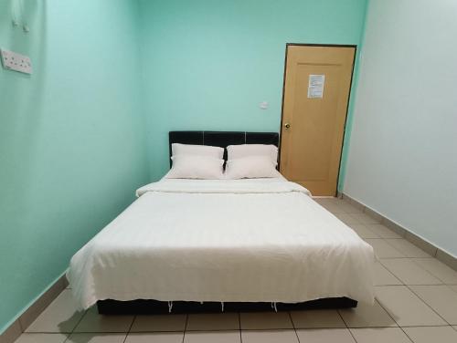 a bed with white sheets and pillows in a room at Kundasang Guesthouse in Kundasang