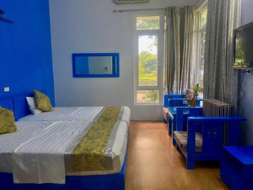 una camera da letto blu con un letto e una finestra di Villa 407 Eureka resort Linh Trường a Thanh Hóa