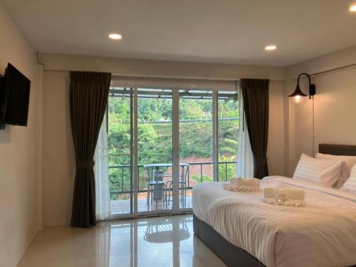 Ban Huai HiaにあるRoute12の大きなベッドとバルコニーのある寝室