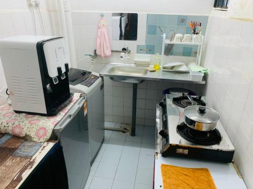 a small kitchen with a stove and a sink at Kluang Towship Homestay in Kluang