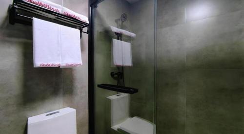 a bathroom with a glass shower and a toilet at Shell Hotel Wuxi Huishan District Chang'an Town in Wuxi