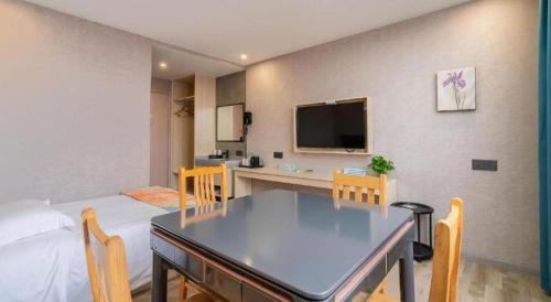 a living room with a dining room table and a kitchen at Shell Hotel Wuxi Huishan District Chang'an Town in Wuxi