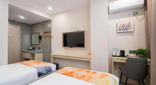a hotel room with two beds and a television at Shell Hotel Wuxi Huishan District Chang'an Town in Wuxi