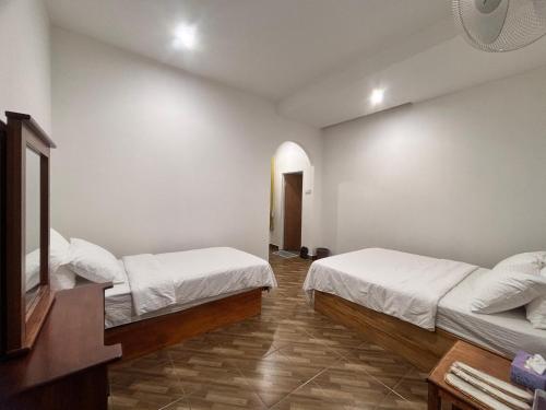 a room with two beds and a mirror in it at Kundasang Guesthouse in Kundasang