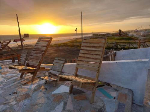 a group of chairs sitting on the beach at sunset at Cabañas en Playas Villamil, Bungalows! in Playas