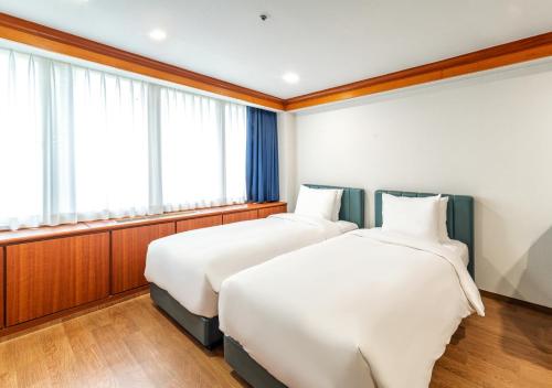 two beds sitting next to each other in a room at Koreana Hotel in Seoul