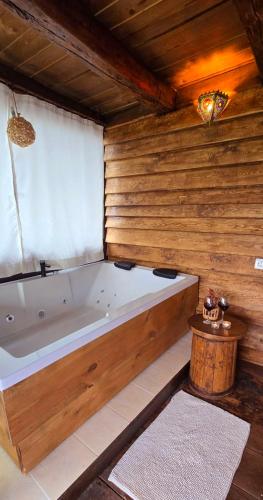 a bath tub in a room with a wooden wall at Вили Панорама Лещен in Leshten