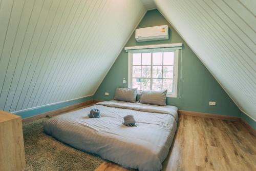 a bedroom with a large bed in a attic at Khaoyai Art Tree in Pong Talong