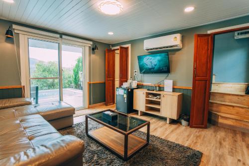 a living room with a couch and a tv at Khaoyai Art Tree in Pong Talong