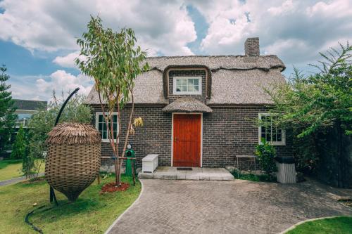 a small brick house with a red door at Khaoyai Art Tree in Pong Talong