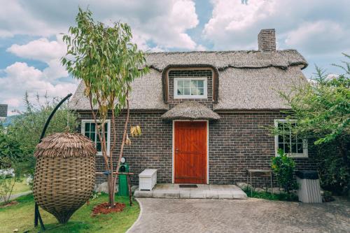 a small brick house with a red door at Khaoyai Art Tree in Pong Talong