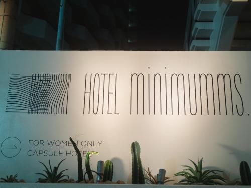 a sign in a window with a bunch of plants at HOTEL minimumms女性専用カプセルホテルWomen only hotel in Naha