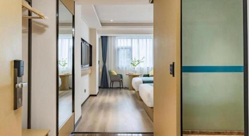 a room with a bedroom with a bed and a table at City Comfort Inn Kunming Dashuying Yejin Hospital Wangdaqiao in Kunming