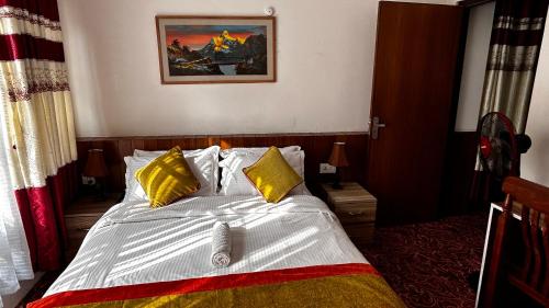 a bedroom with a bed with yellow pillows at Raniban Suites - Apartment Home in Kathmandu
