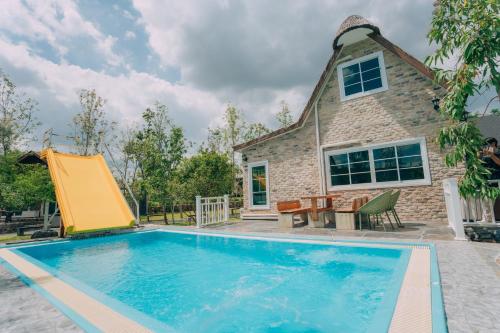 a swimming pool in front of a house at Khaoyai Art Tree in Pong Talong