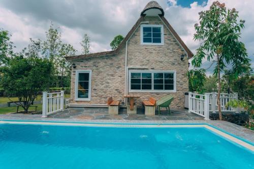 a house with a swimming pool in front of a house at Khaoyai Art Tree in Pong Talong