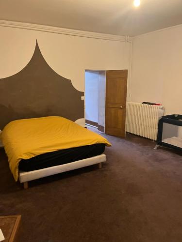 une chambre avec un lit avec une couverture jaune dans l'établissement Maison avec cour, à Neuvy-sur-Barangeon
