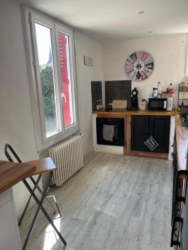 Cette chambre comprend une cuisine avec un comptoir et une fenêtre. dans l'établissement Maison avec cour, à Neuvy-sur-Barangeon