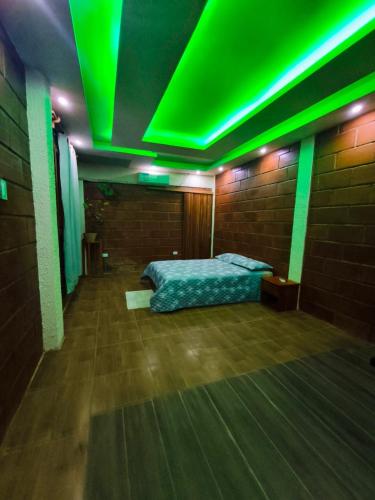 a room with a bed with green lights on it at Cabañas en Playas Villamil, Bungalows! in Playas