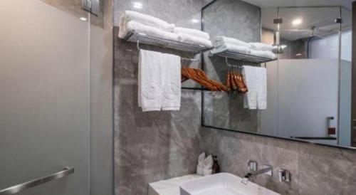 a bathroom with a sink and a mirror and towels at Xiamen Seashine Lakeview Hotel in Xiamen