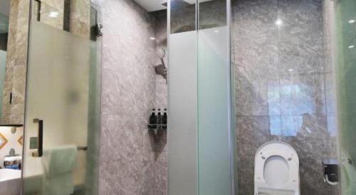 a bathroom with a toilet and a glass shower at Xiamen Seashine Lakeview Hotel in Xiamen