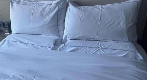 a white bed with white pillows on top of it at Xiamen Seashine Lakeview Hotel in Xiamen