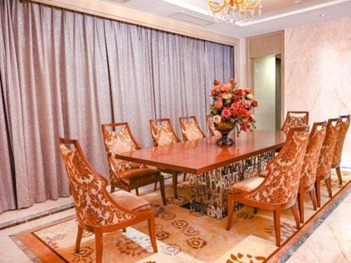 a dining room with a wooden table and chairs at Royal Tulip Hotel Zhujiajiao Shanghai in Shanghai