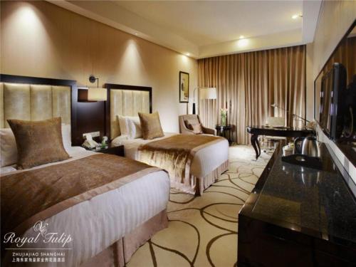 a hotel room with two beds and a piano at Royal Tulip Hotel Zhujiajiao Shanghai in Shanghai