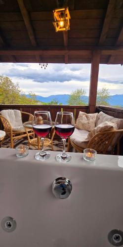 two glasses of wine sitting on top of a table at Вили Панорама Лещен in Leshten