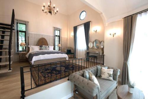 a bedroom with a bed and a couch at The Bluesky Resort @ Khao Kho in Campson