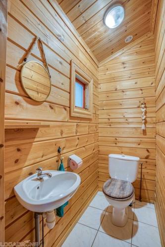 La salle de bains en bois est pourvue d'un lavabo et de toilettes. dans l'établissement Chalet 17 tournesol Mauroux, à Mauroux