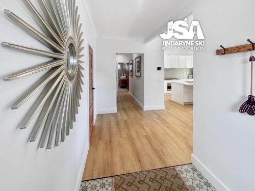 a living room with a large silver clock on the wall at Allenvale in Jindabyne