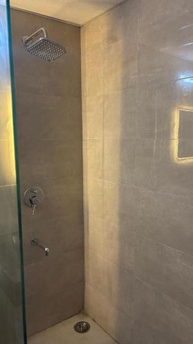 a shower with a glass door in a bathroom at Aura Stays in Lucknow