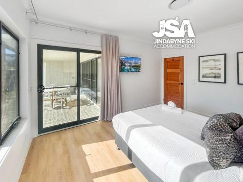 a bedroom with a bed and a balcony at Allenvale in Jindabyne